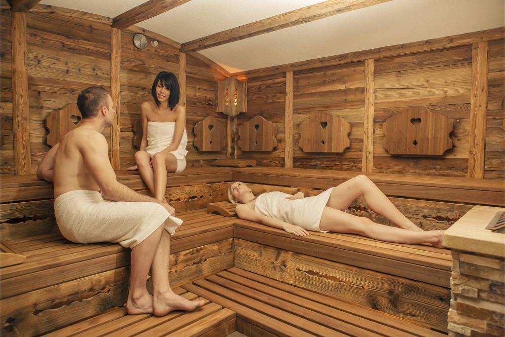 zwei Frauen und ein Mann in der finnischen Sauna